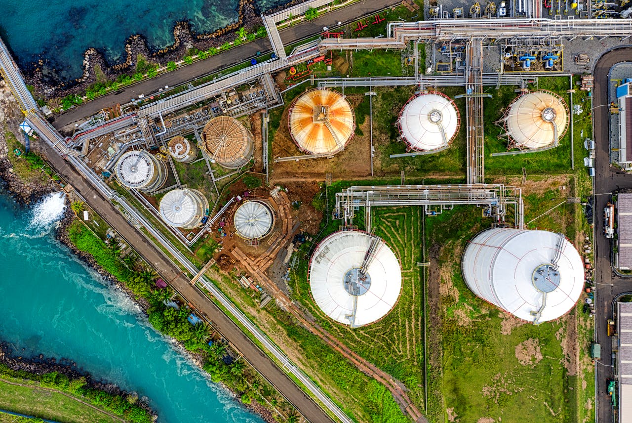 Aerial view of an industrial complex near a river in Banten, Indonesia, showcasing storage tanks.